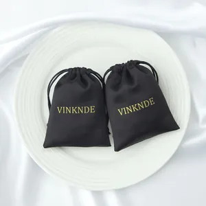 Bolsa de regalo de satén negro con cordón y elegante logo dorado