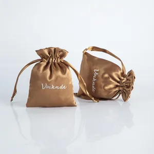 Close-up of champagne satin drawstring jewelry pouches with silk-like texture