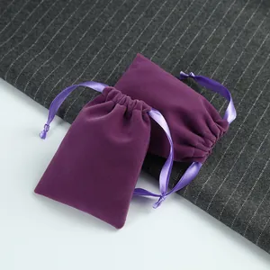 Détail rapproché de pochettes à bijoux en velours violet avec cordon en satin lisse