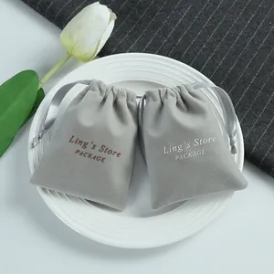 Detailed macro shot of gray velvet drawstring gift pouches for jewelry on white plate