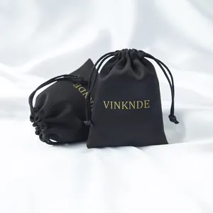 Bolsa de regalo de satén negro con logo dorado VINKNDE sobre seda blanca