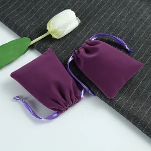 Vue détaillée de deux pochettes à bijoux en velours violet sur fond de tissu gris