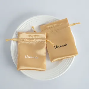 Elegant golden satin drawstring jewelry pouch set for premium gift packaging and storage