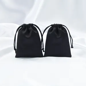 Detalle de dos bolsas de satén negro de alta calidad con cordón para regalos elegantes