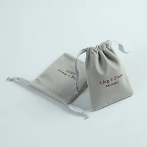 Macro view of premium light gray velvet jewelry drawstring pouch with silk ribbon detail