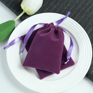 Vue détaillée de pochettes en velours violet à cordon pour bijoux et emballages cadeaux