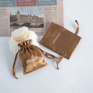 Detailed view of a premium brown satin drawstring pouch with white Vinknde embroidery