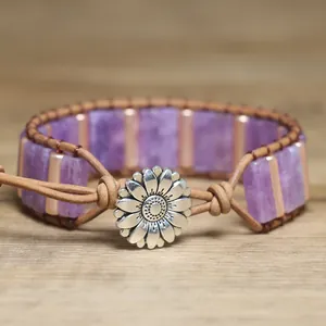 Close-up of bohemian woven bracelet with purple stones and silver sunflower charm