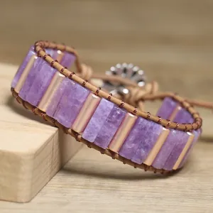 Detailed view of a purple natural stone woven wrap bracelet with gold metal bars.