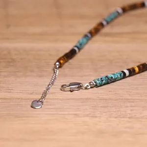 Gedetailleerd zicht op handgemaakte choker met tijgeroogkralen en karabijnsluiting.
