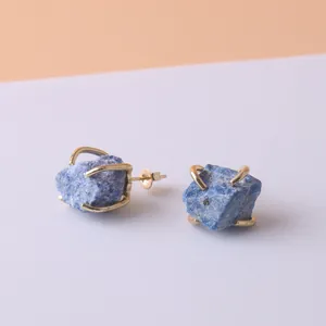 Close-up of irregular blue raw stone earrings with gold-plated four-prong setting