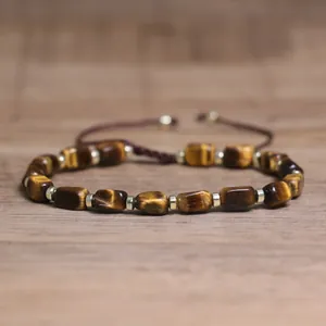 Detail view of natural tiger eye stone bracelet with golden metal spacers.