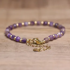 Close-up of handmade 4x6mm purple natural stone bracelet with golden beads and lobster clasp
