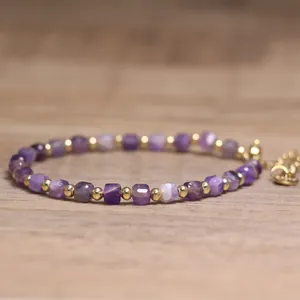 Macro view of purple amethyst stone beads and gold spacers on a delicate bracelet