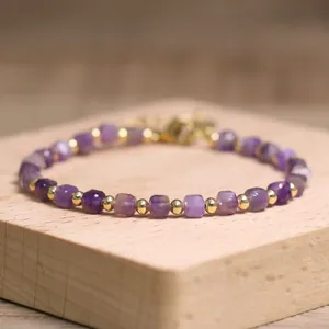 Close-up of purple amethyst cube beads and gold accents on a natural stone bracelet
