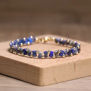 Detailed view of handcrafted Tila bead bracelet with blue stones and gold accents.