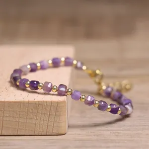 Close-up macro view of handmade amethyst beaded bracelet with gold spacer beads