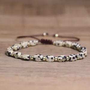 Detail of handmade bracelet with dalmatian jasper beads and adjustable cord.