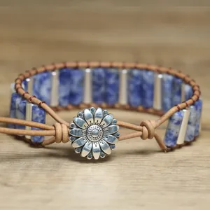 Detailed view of retro braided leather bracelet with blue stones and sunflower clasp.