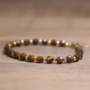 Close-up of faceted tiger eye stone beads and gold spacers on a handmade bracelet