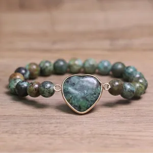 Close-up of green mottled natural stone beaded bracelet with heart-shaped pendant