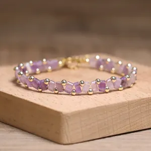 Detailed view of handmade purple Tila bead bracelet with tiny gold beads on wood