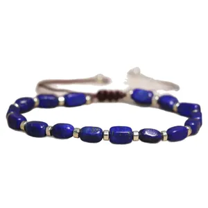Handmade natural stone bracelet with dark blue beads and silver spacers on brown cord.