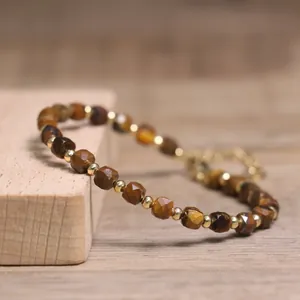 Close-up of faceted Tiger Eye stone beaded bracelet with gold spacer beads.