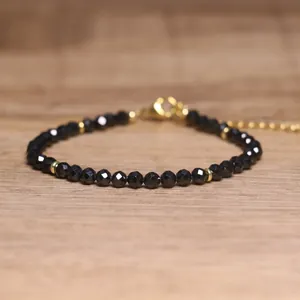 Close-up of black faceted gemstone beads on a bohemian style adjustable bracelet.