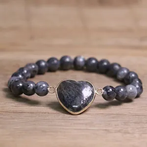 Close-up of a natural grey labradorite beaded bracelet with a gold heart charm