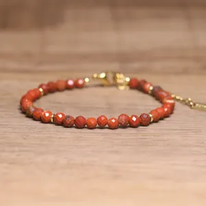 Macro view of faceted red natural stone beads on a bohemian style adjustable bracelet