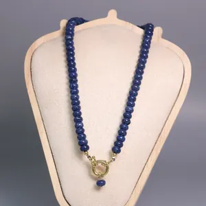 Vista detallada de collar de cuentas de piedra azul natural con elegante cierre marinero dorado.