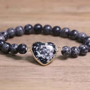 Close-up view of 8mm natural stone beaded bracelet with gold-framed heart charm