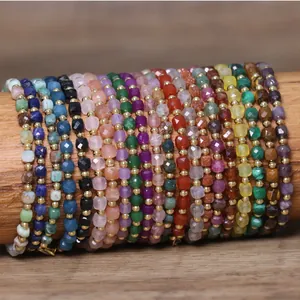 Macro view of colorful natural stone beaded bracelets with gold spacers on wood