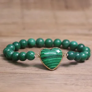 Close-up of 8mm green malachite-style beaded bracelet featuring a gold-framed heart centerpiece.