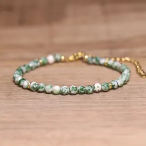 Detail view of faceted green natural stone beaded bracelet with gold accents