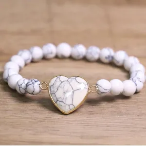 Close-up of white marble stone beaded bracelet with golden heart centerpiece