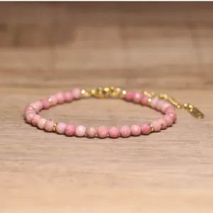 Close-up of handmade pink faceted natural stone beaded bracelet with gold accents