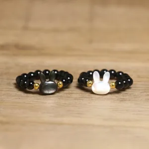 Detailed macro view of beaded rabbit rings featuring shell pearl and black stones