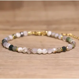 Close-up detail of a handmade Bohemian bracelet with faceted natural stones and gold beads