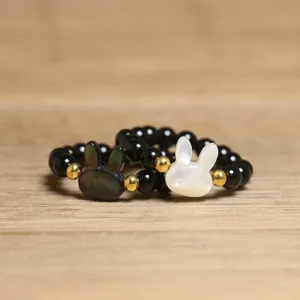 Detailed view of handmade cute shell rabbit beaded rings with black natural stones