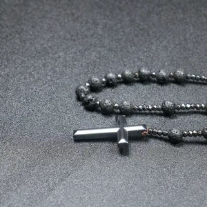 Detailopname van een rozenkransketting met 8mm lavasteen kralen en hematiet kruis.