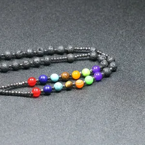 Detailopname van 8mm vulkanische lavastenen en chakra-stenen aan een zwarte halsketting.