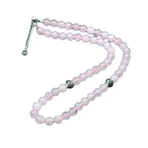 Elegante collar de cuentas de cuarzo rosa con cadena plateada sobre fondo blanco puro.