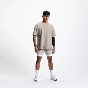 Vue d'ensemble short de course beige double couche et t-shirt oversize pour hommes.