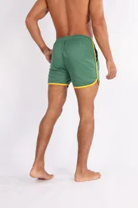 Detailansicht der grünen Herren-Sportshorts aus schnelltrocknendem Mesh mit gelbem Rand.
