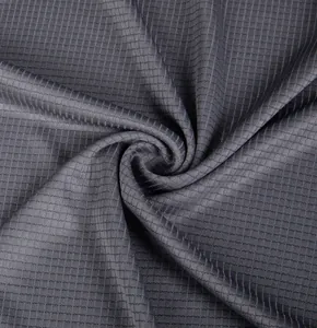Macro detail of dark grey quick-dry breathable fabric with small square grid pattern.