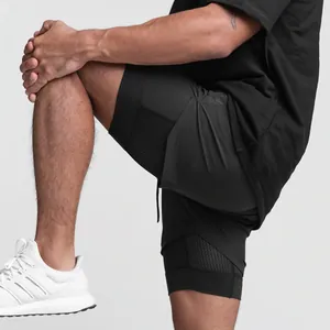 Gros plan montrant le design double couche du short de sport noir pour homme.