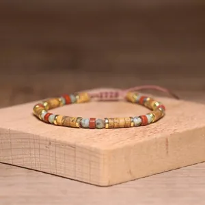 Macro view of 2x4mm natural stone beads on a handmade adjustable bracelet