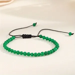 Detailed view of 4mm natural green agate beads on an adjustable black woven cord bracelet